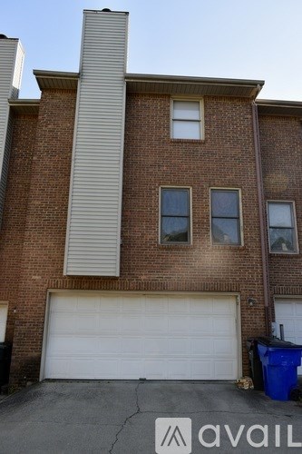 A two-story brick building with a white garage door.