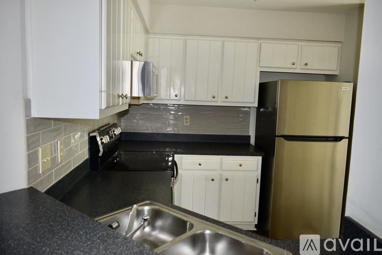 A kitchen with a black counter top and white cabinets.