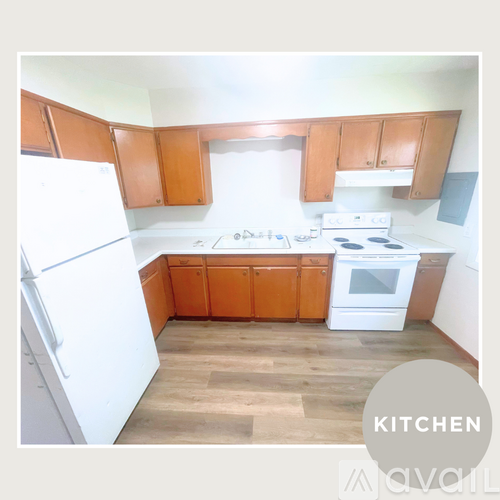 A kitchen with wooden cabinets and white appliances.