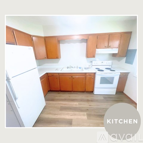 A kitchen with wooden cabinets and white appliances.