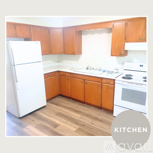 A kitchen with wooden cabinets and a white fridge.