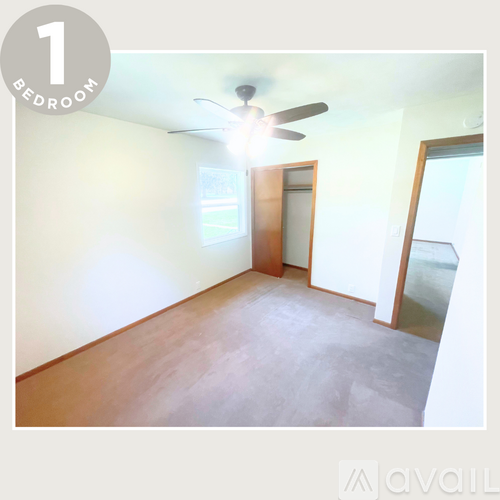 A bedroom with a ceiling fan and a door leading to a balcony.