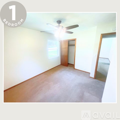 A bedroom with a ceiling fan and a door leading to a balcony.