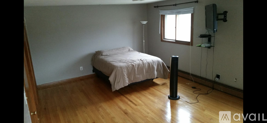 A bedroom with a bed, a lamp, and a television.