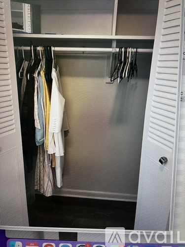Clothes hanging on a rack in a closet.