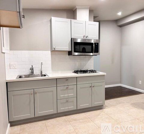 A kitchen with white cabinets and a stainless steel range hood.