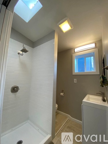 A bathroom with a skylight and a window.