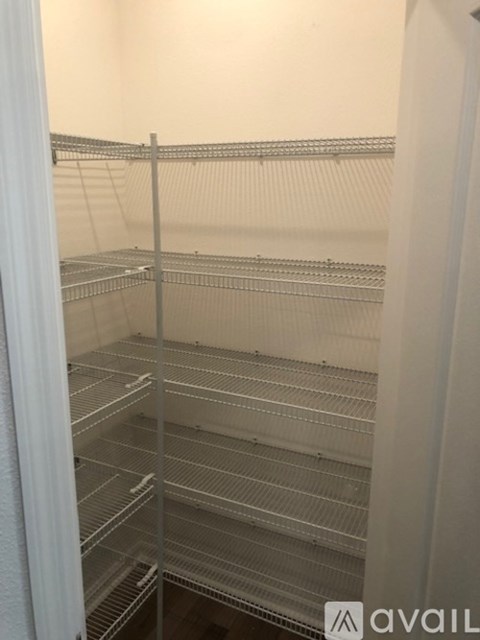 Empty shelves in a white pantry.