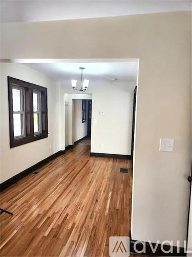 A hallway with wooden floors and a white door.