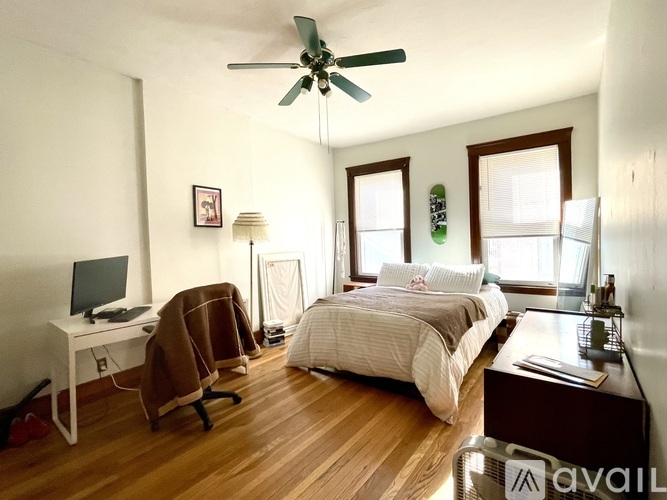 A bedroom with a bed, desk, and chair.