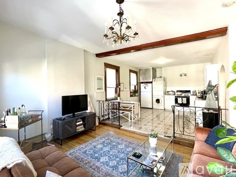 A living room with a brown couch and a glass coffee table.