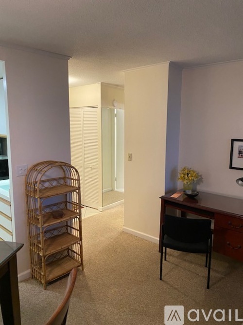 A room with a chair, a shelf, and a desk.