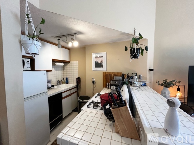 A kitchen with a white fridge and a white tiled counter.