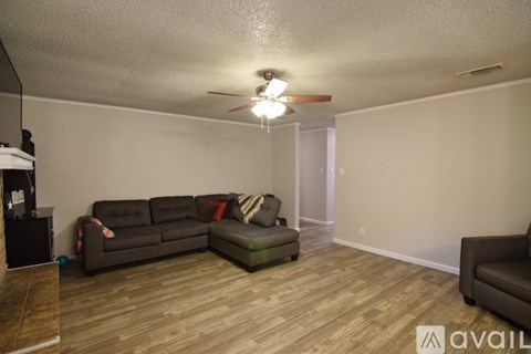 A living room with a grey couch and a wooden floor.