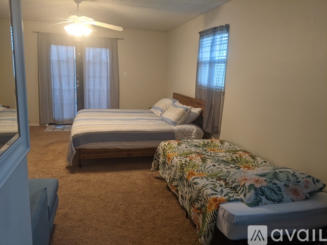 A bedroom with two beds and a ceiling fan.