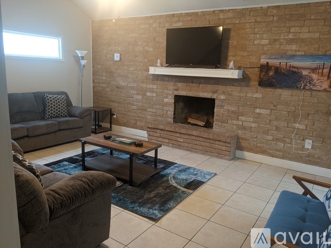 A living room with a couch, chair, and a fireplace.