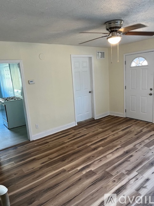 A room with wooden flooring and a ceiling fan.