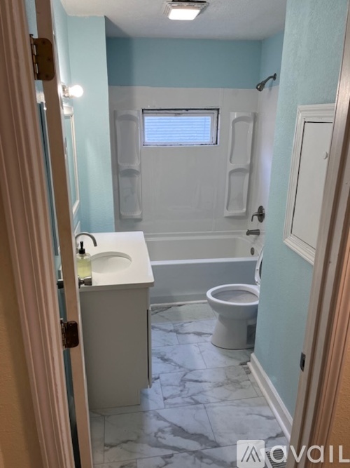 A bathroom with a toilet, sink, and tub.