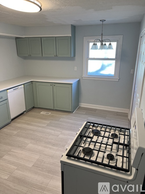 A kitchen with a stove top oven and cabinets.