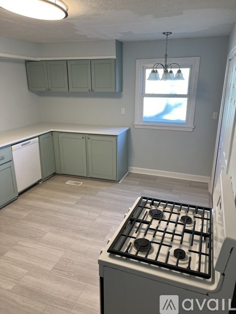 A kitchen with a stove top oven and cabinets.