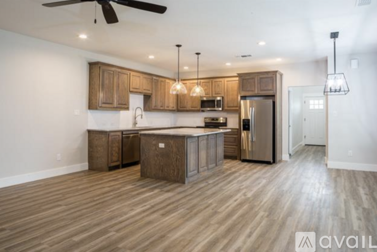 A kitchen with wooden cabinets and a refrigerator.