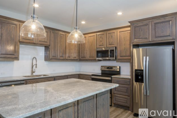 A kitchen with wooden cabinets and a marble countertop.