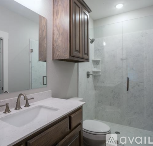 A bathroom with a toilet, sink and mirror.