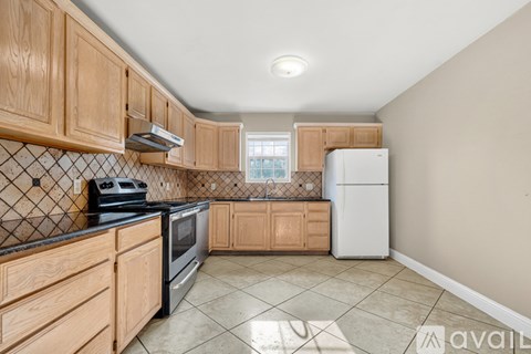 A kitchen with wooden cabinets and a black stove top oven.