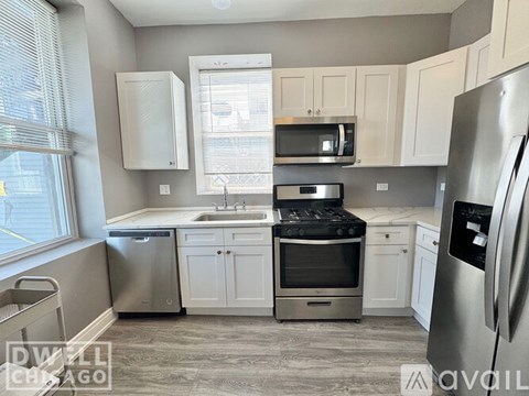A kitchen with white cabinets and stainless steel appliances.