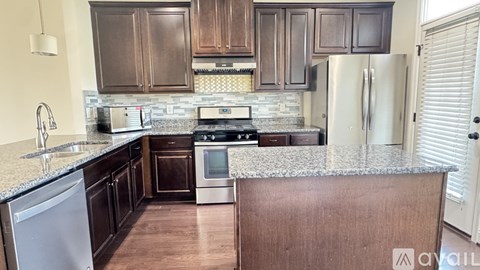 A kitchen with brown cabinets and a granite countertop.