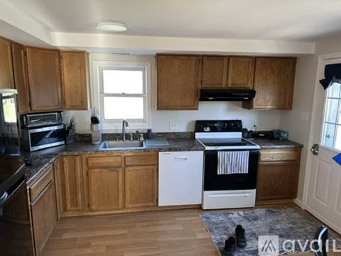 A kitchen with wooden cabinets and a black stove top oven.