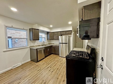 A kitchen with wooden floors and a black stove top oven.