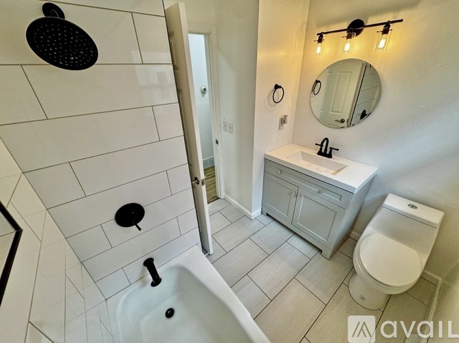 A bathroom with a white tub and toilet.