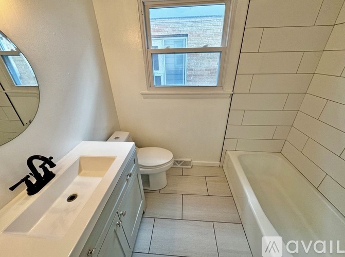A bathroom with a tub, toilet, and sink.