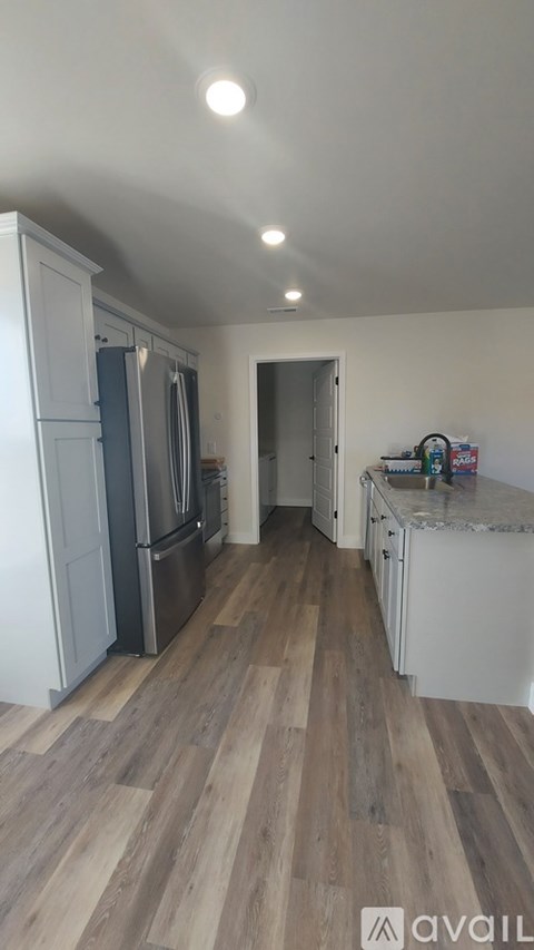 A kitchen with white cabinets and a wooden floor.