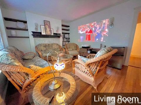 A living room with a wicker chair and a lit light bulb.