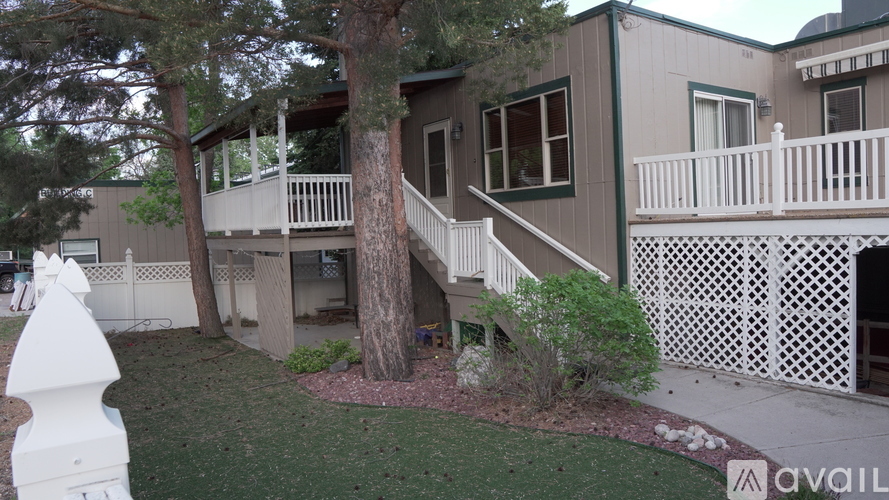 A house with a white picket fence and a tree in front.