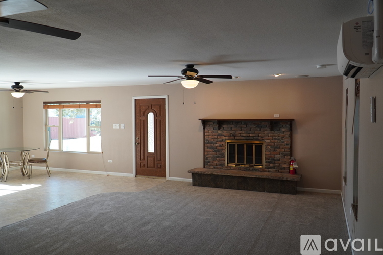 A living room with a fireplace and a ceiling fan.
