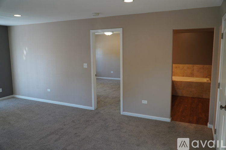 A room with a carpeted floor and a doorway leading to another room.