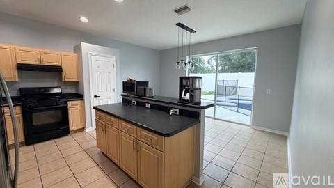 A kitchen with wooden cabinets and black countertops.