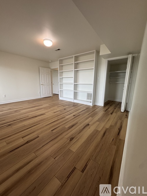 A room with wooden flooring and white walls.