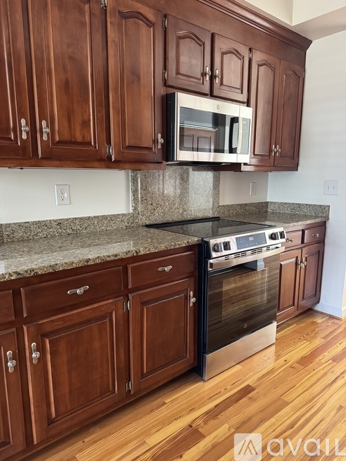 A kitchen with wooden cabinets and a granite countertop.