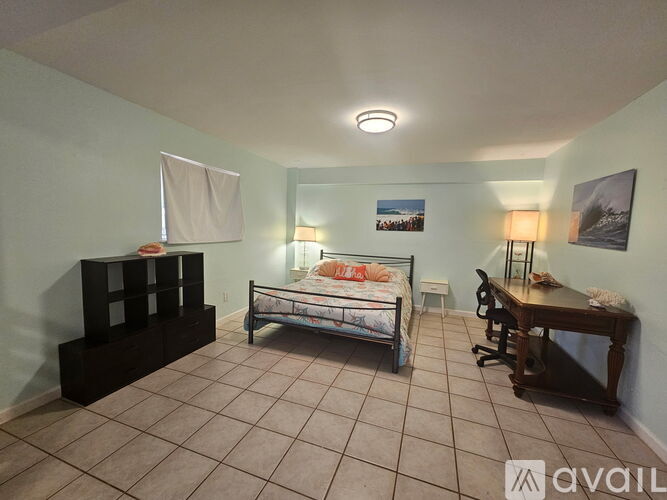 A bedroom with a bed, desk, and chair.