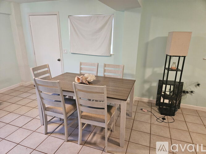 A dining room with a table and chairs.