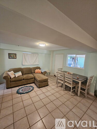 A living room with a couch, chairs, and a dining table.