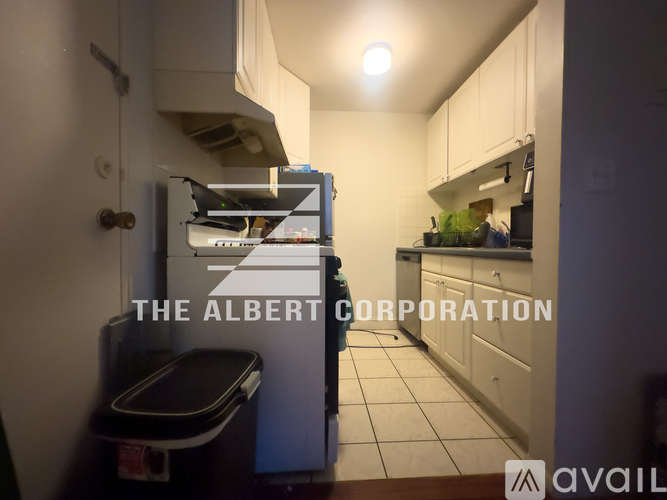 A kitchen with a white fridge and a black stove top.