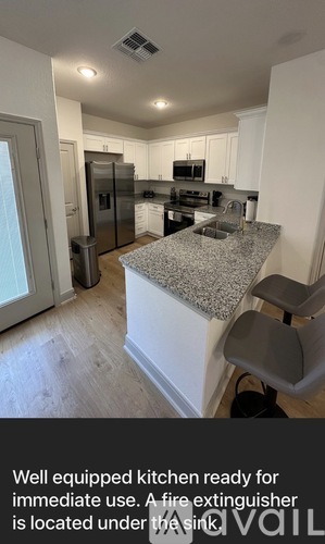A kitchen with a granite countertop and stainless steel appliances.