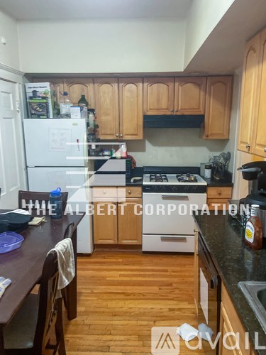 A kitchen with wooden cabinets and a white fridge.