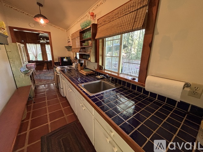 A kitchen with brown tiles and white cabinets is available for rent.