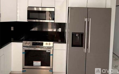 A kitchen with a black oven and a white fridge.